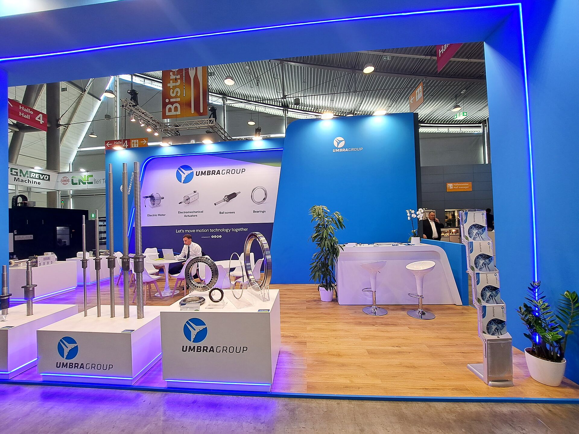 UmbraGroup stand front view with blue portal and product plinths